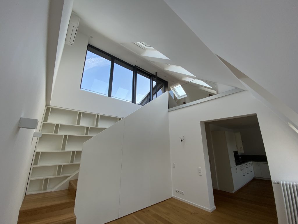 Innenausbau eines Treppenaufgangs mit Treppe und Einbau-Wandregal von den Meistern der TST Tischlerei.